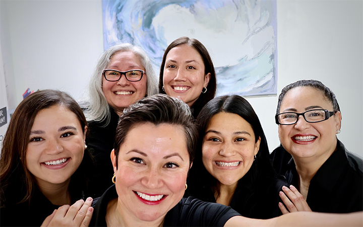 Doctor Bianca Sanchez smiling with five members of dental team in San Antonio