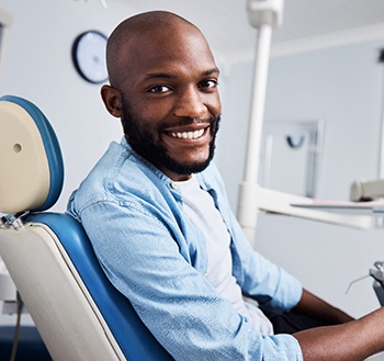 Bearded man sitting in dental chair and smiling