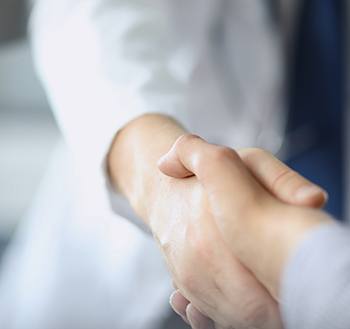 Close-up of dentist shaking patient’s hand