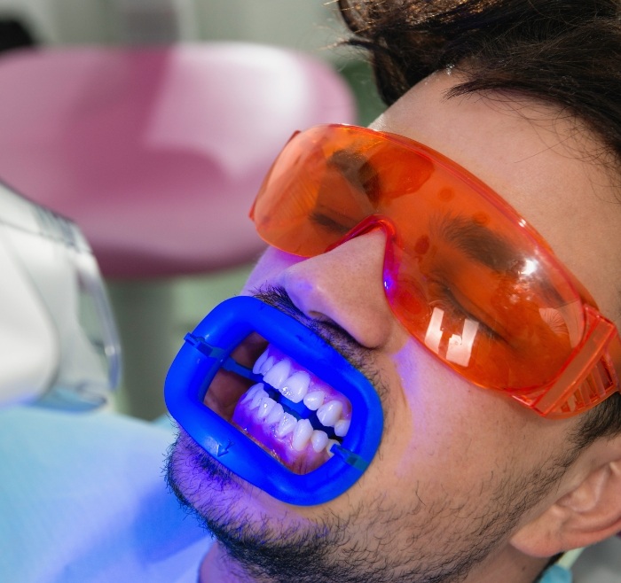 Man in dental chair receiving professional teeth whitening