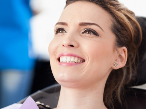 Smiling woman leaning back in dental chair