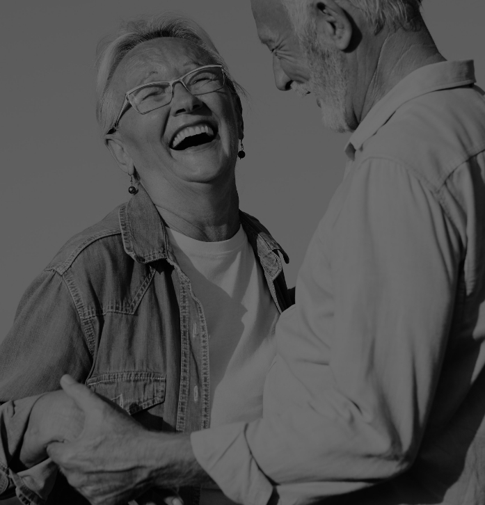 Senior man and woman laughing and holding hands