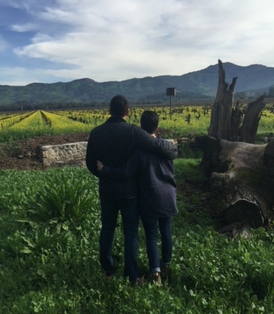 Doctor Sanchez with her husband looking at a green field with mountains in the background