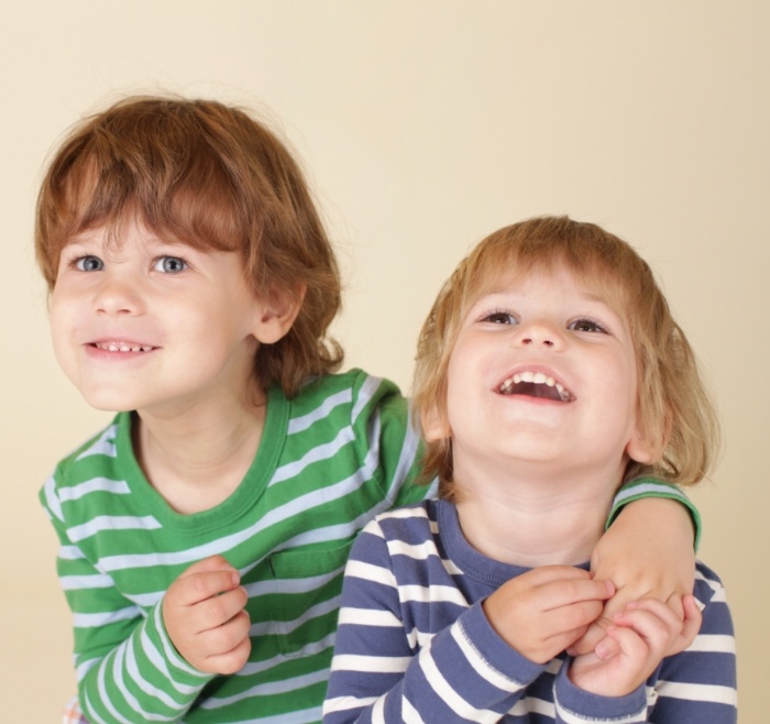 Two smiling children in striped shirts